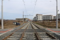 Za zastávkami Holyně je umístěn prostor pro přecházení chodců a tramvajová trať míří přímým úsekem.