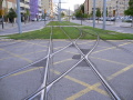 Kruhový objezd poblíž zastávky Montesa s kolejovým trojúhelníkem jímž projíždí linky T1, T2 a T3, trať je zatravněna a bezpečný průjezd tramvají je opět zajištěn světelnou signalizací | 10.-15.7.2008