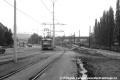 Na snímku mířícím k branickému nádraží se z původní tratě v ulici Na Mlejnku vrací souprava vozů T3 neznámých evidenčních čísel vypravená na linku 17. Vpravo je již ve výstavbě současná přeložka. Obě tratě se na snímku setkávají. | říjen 1986