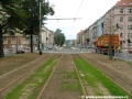 Zatravněná tramvajová trať míří ke křižovatce se Zelenou ulicí.