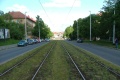 Přímý úsek tramvajové tratě ve středu Průběžné ulice se zatravněným krytem.