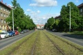 Přímý úsek tramvajové tratě ve středu Průběžné ulice se zatravněným krytem.