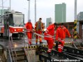 Pracovníci technické kontroly přinášejí vyztuženou spojovací tyč určenou k vytažení vozu. | 22.3.2007