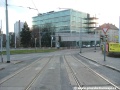 Za zastávkami Strašnická se tramvajová trať v pravém oblouku stáčí do středu ulice V Olšinách.