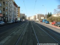 Přímý úsek tramvajové tratě zřízené velkoplošnými panely BKV na zvýšeném tělese ve středu ulice V Olšinách.