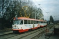 V zastávce Brusnice odbavuje cestující souprava strašnických vozů T3 #6690+#6691 na lince 22 s celovozovou reklamou na Emarko. Na snímku je patrný neutěšený stav tělesa tramvajové tratě, kdy zákryt tvořil všelijak rozpraskaný asfaltový koberec. | prosinec 1993